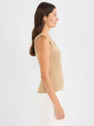 Tan ribbed scoop neck tank top on a model, shown in profile.
