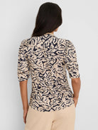 Tan and navy abstract swirl top with ruffled collar and puff sleeves.