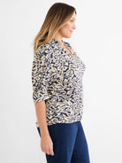 Cream & navy abstract swirl top with 3/4 sleeves & V-neck with tan braided trim.