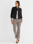 Black textured cropped jacket featuring frayed trim is paired with slim beige and black geometric print trousers.