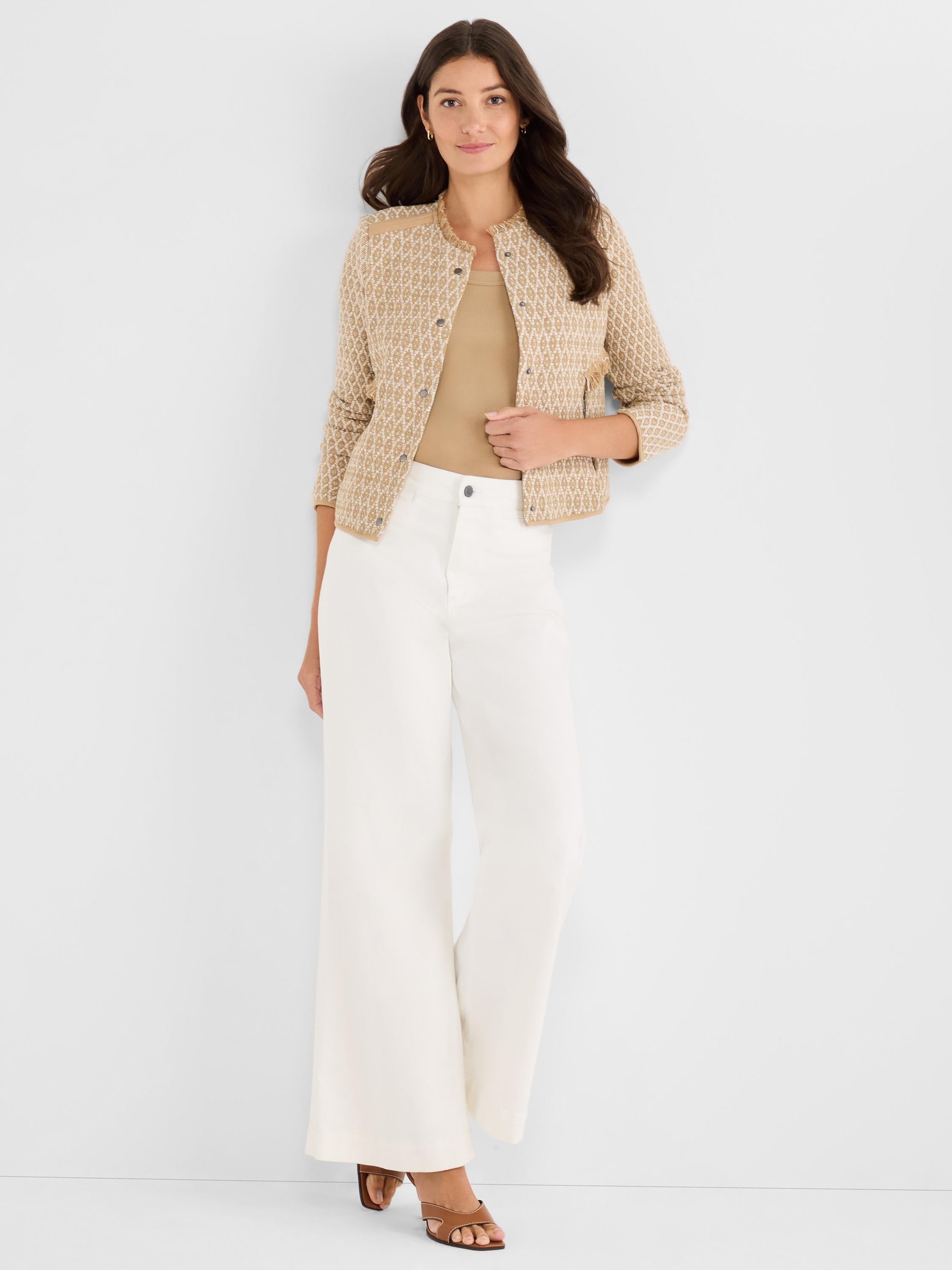 Cropped tan and cream patterned jacket with a collarless neckline, frayed trim details, and a front snap closure.