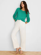 Green pointelle sweater featuring openwork knit details on the yoke and long sleeves.