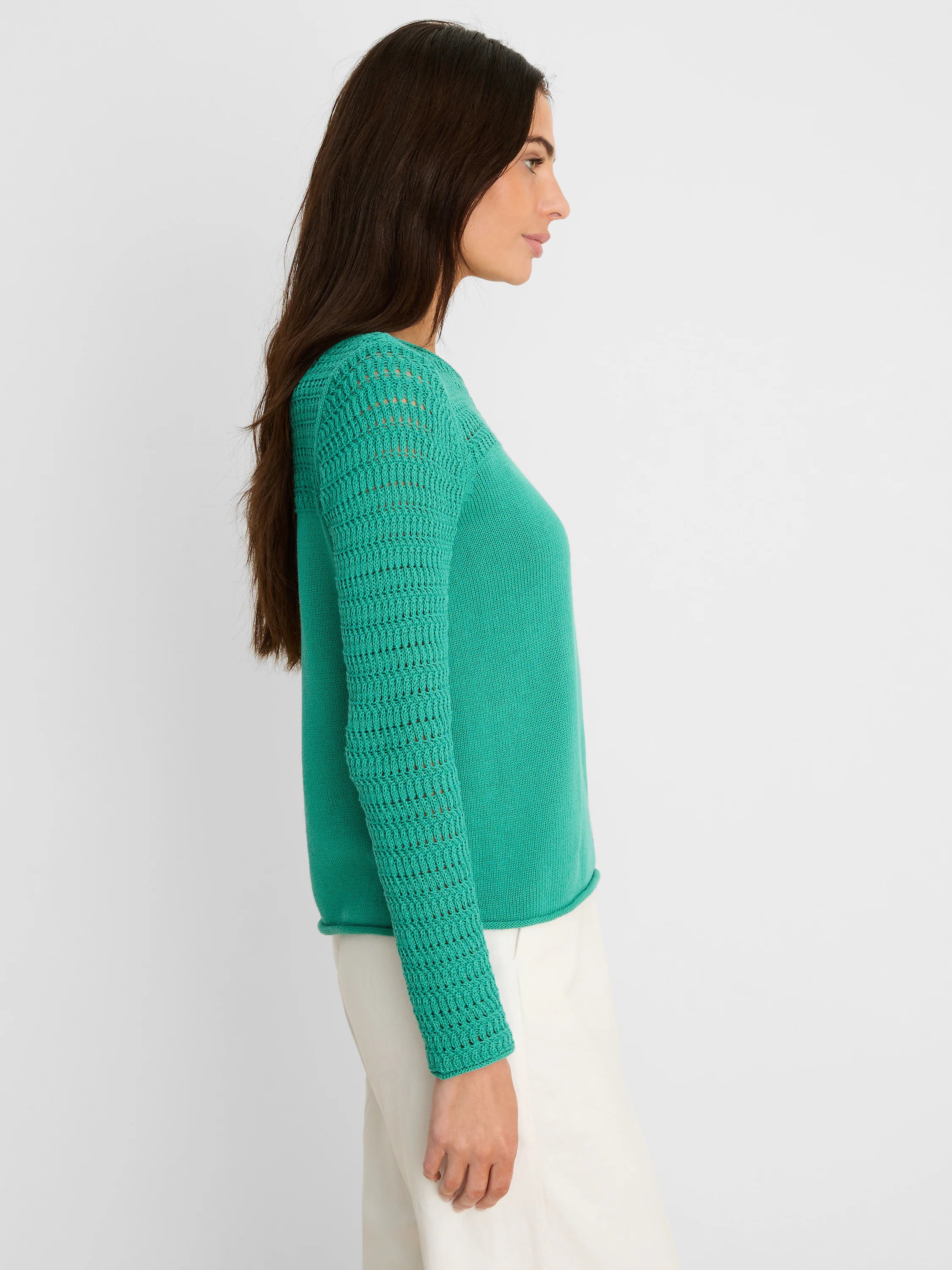 Emerald green sweater with openwork pointelle knit sleeves and a smooth knit body.