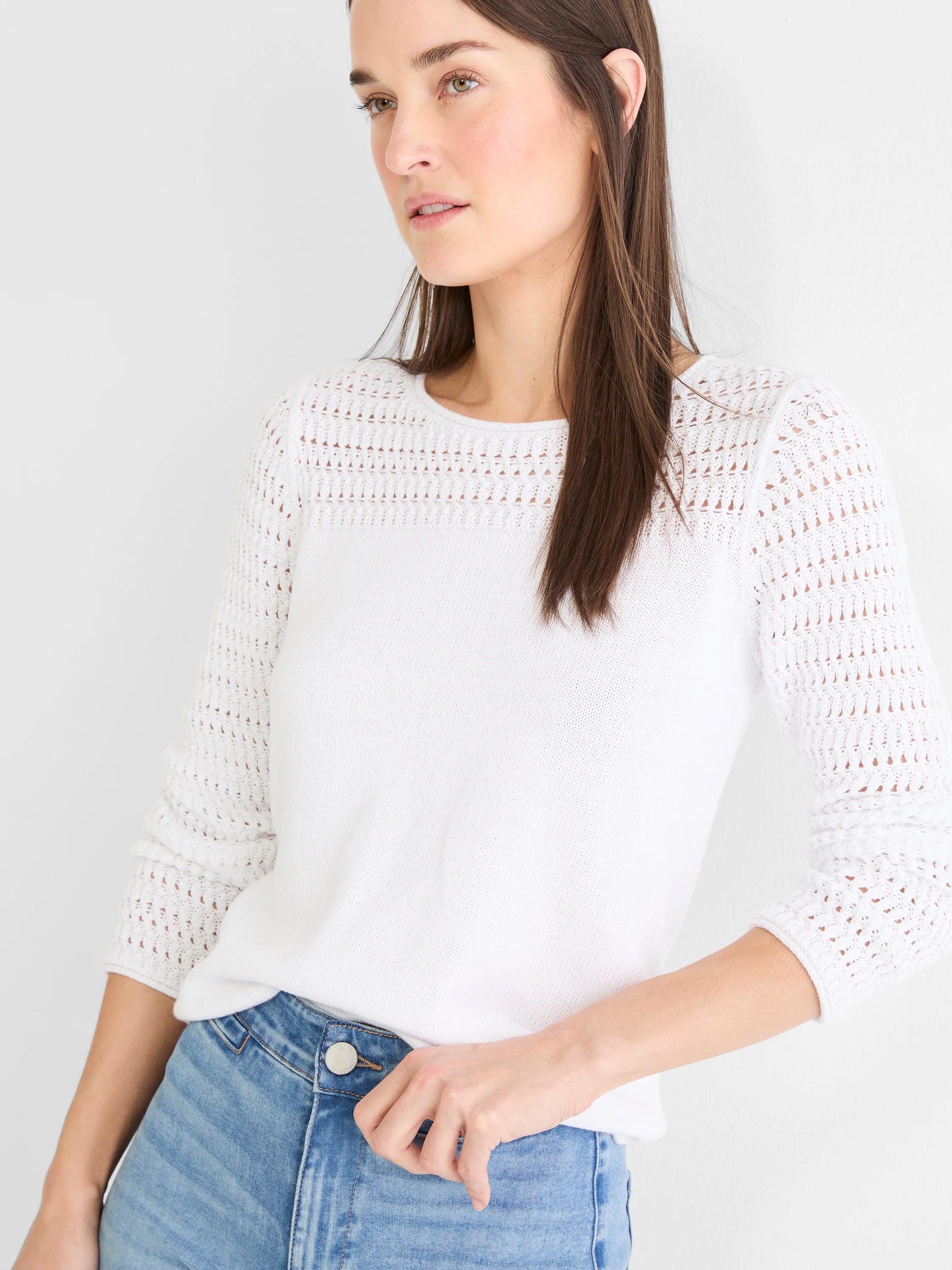 White crew neck sweater with 3/4 sleeves. Features small decorative holes in knit on shoulders and sleeves.