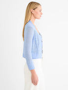 Light blue featherknit open cardigan with a subtle ruffled edge and ribbed cuffs.