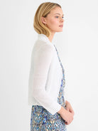 White, lightweight featherknit cardigan with a ruffled collar and 3/4 ribbed sleeves.