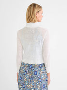 Off-white sheer featherknit cardigan with ruffled mock neck, ribbed cuffs & hem, shown from back.