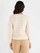 Cream sweater with long sleeves featuring a semi-fitted silhouette and an intricate beige ripple knit pattern.
