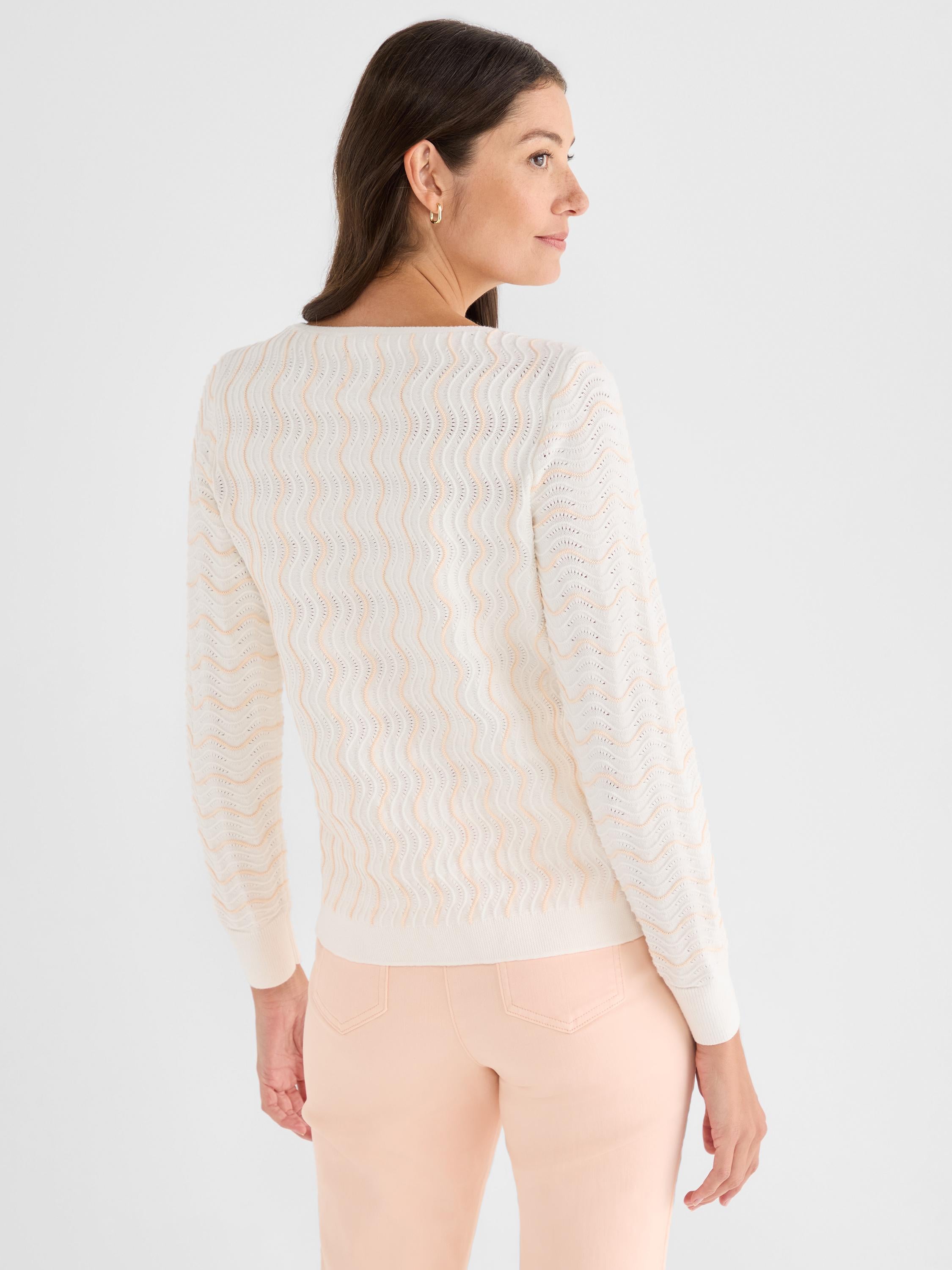 This white fitted sweater features a peach wavy knit pattern and long sleeves for a soft textured look.