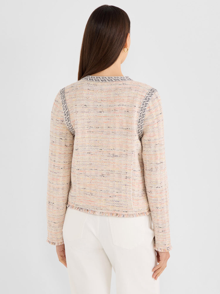 The model wears a fitted, collarless, multicolor tweed jacket with geometric trim and a fringed hem.