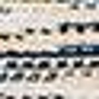 Light tan swatch featuring rows of blurry black dots & a distinct dark horizontal line. Appears t...