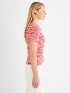 Short-sleeve sweater tee with horizontal stripes in bright pink, red, orange, and off-white spacedye knit.