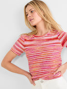 Short-sleeve crew neck sweater tee with textured spacedye knit in horizontal pink, orange, red, and white stripes.