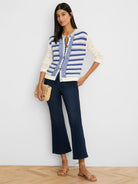 Off-white knit cardigan with horizontal blue stripes and a vertical blue chevron pattern on the front.