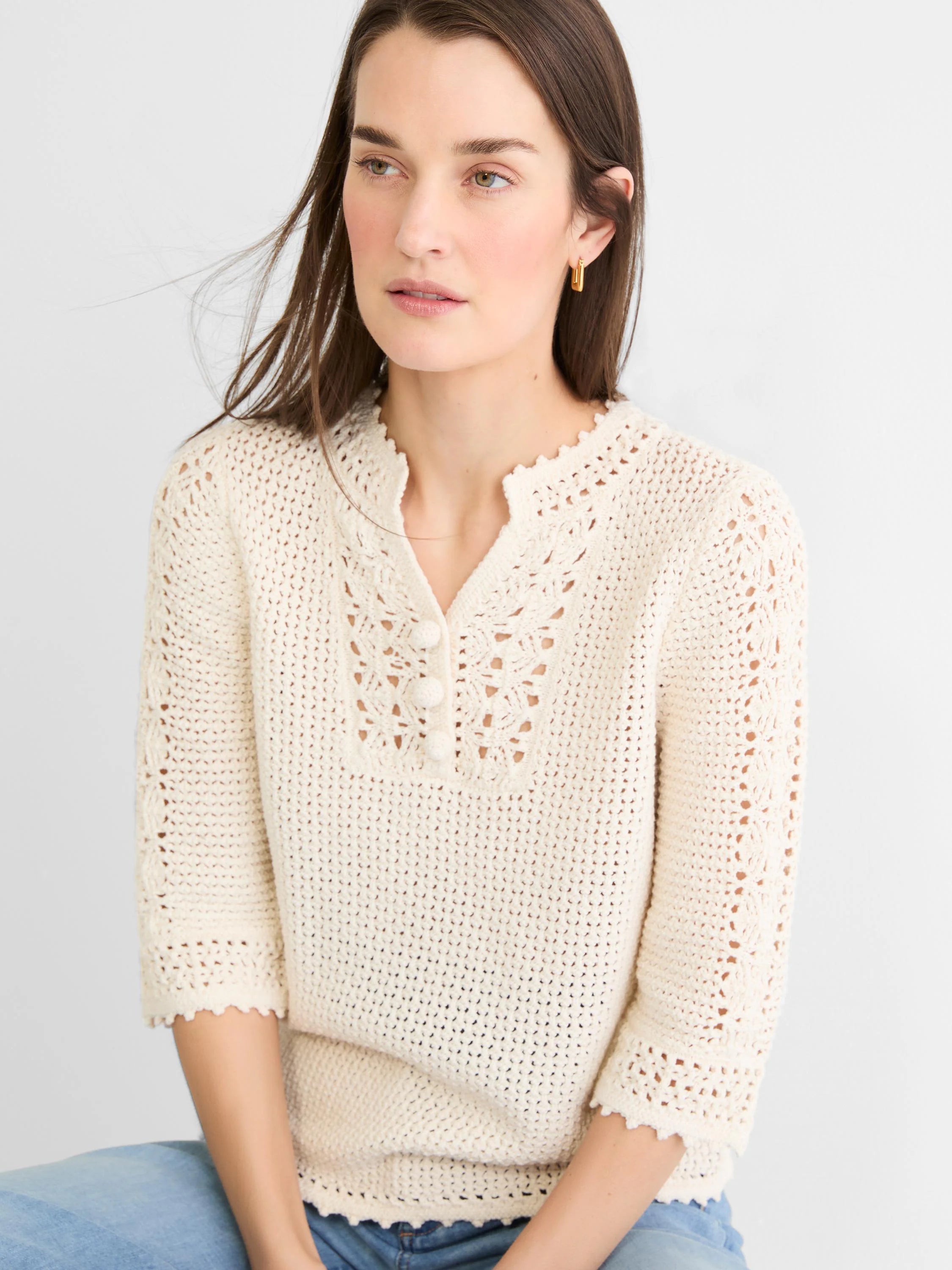 Cream crochet mesh sweater with openwork details at the V-neck, 3 buttons, and scalloped trim.