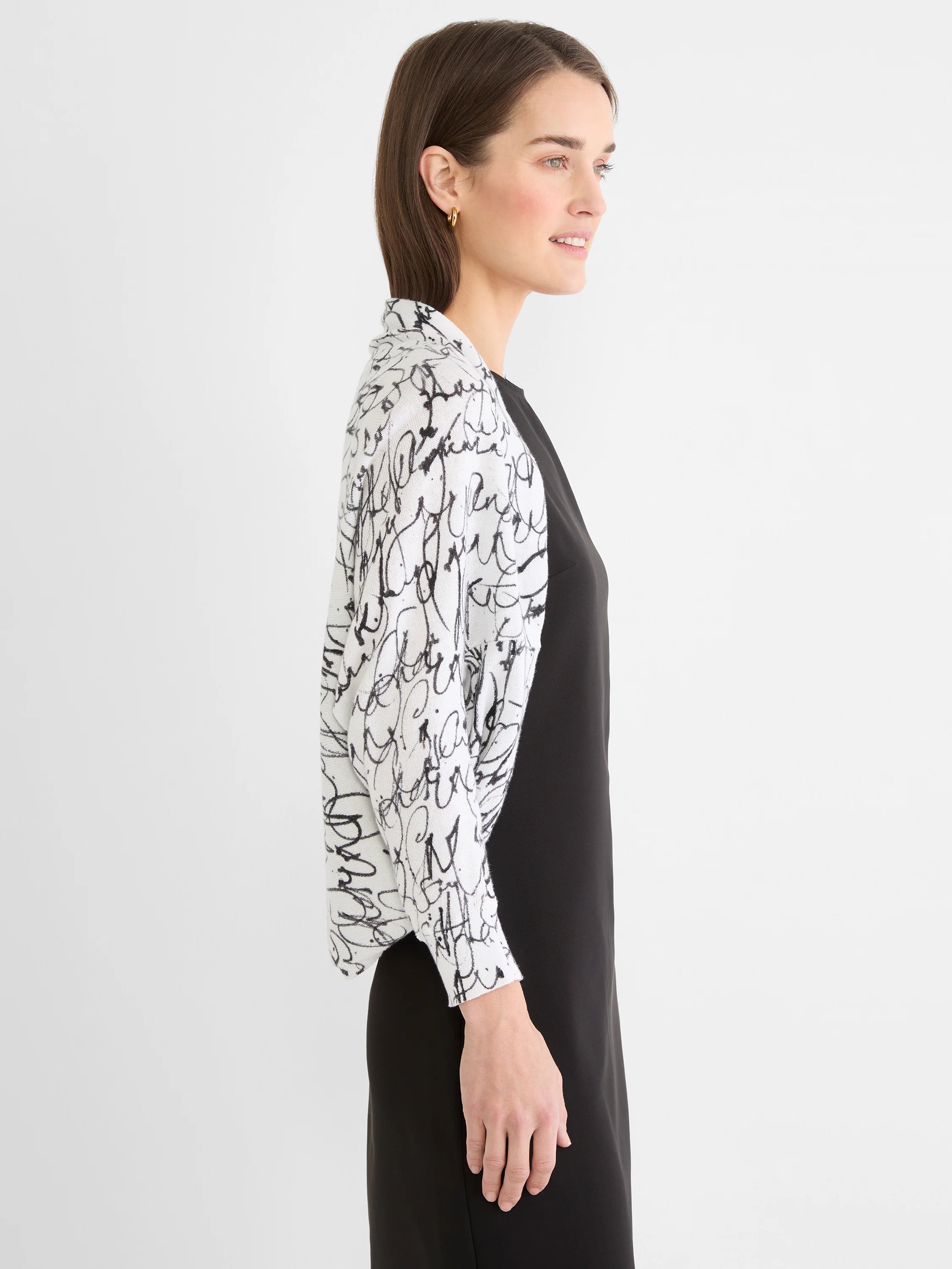 White open-front shrug cardigan with black cursive pattern.
