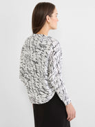 White Cursive Shrug Cardigan with black abstract scribbled pattern. Loose fit, seen from the back.