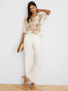 Cream knit sweater with tan abstract cobblestone pattern and short sleeves.