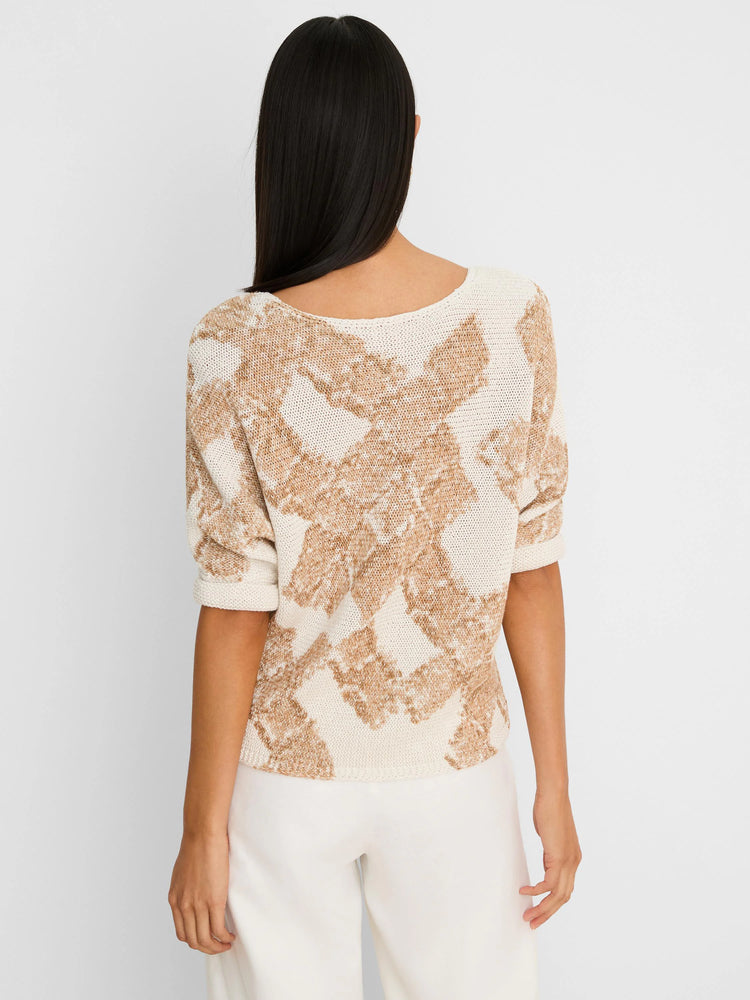 Back view of a cream and tan knit sweater with a cobblestone pattern and elbow-length sleeves on a model.