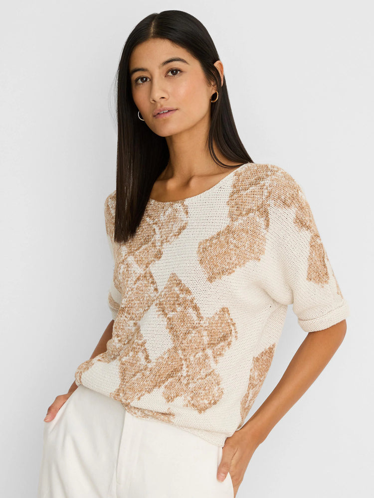 Off-white knit sweater with light brown cobblestone stamp pattern, boat neck, short sleeves, and rolled cuffs.
