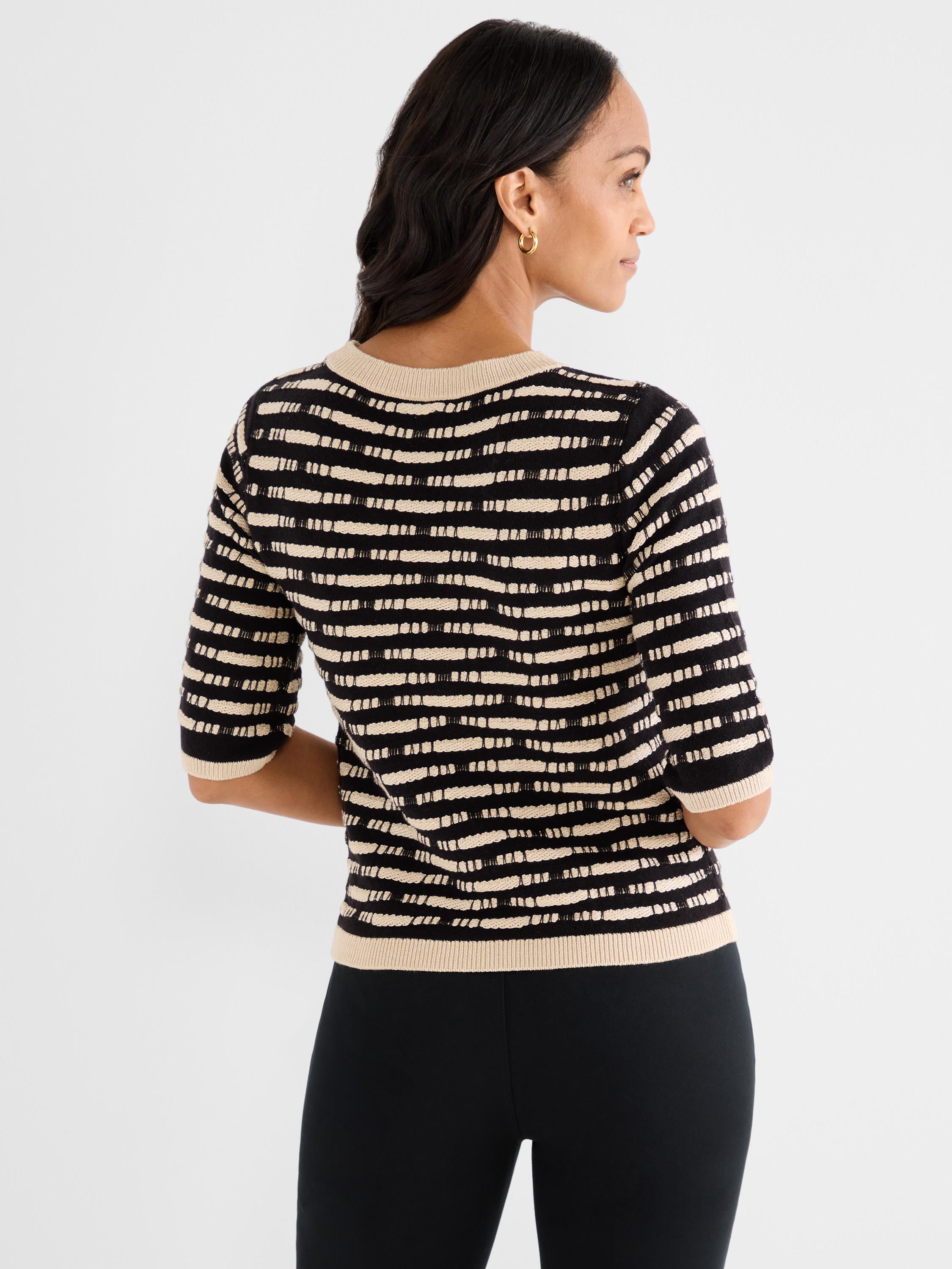 The model wears a fitted black and beige half-sleeve knit top with textured horizontal stripes and contrasting trim.