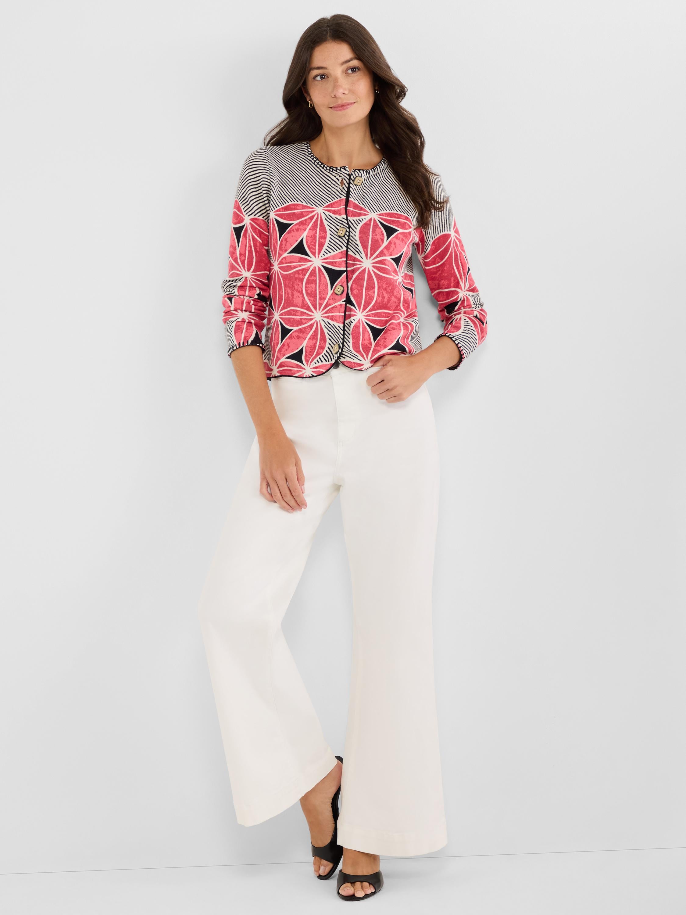Fitted, cropped cardigan featuring a pink and black floral geometric pattern, contrast piping, and button front closure.