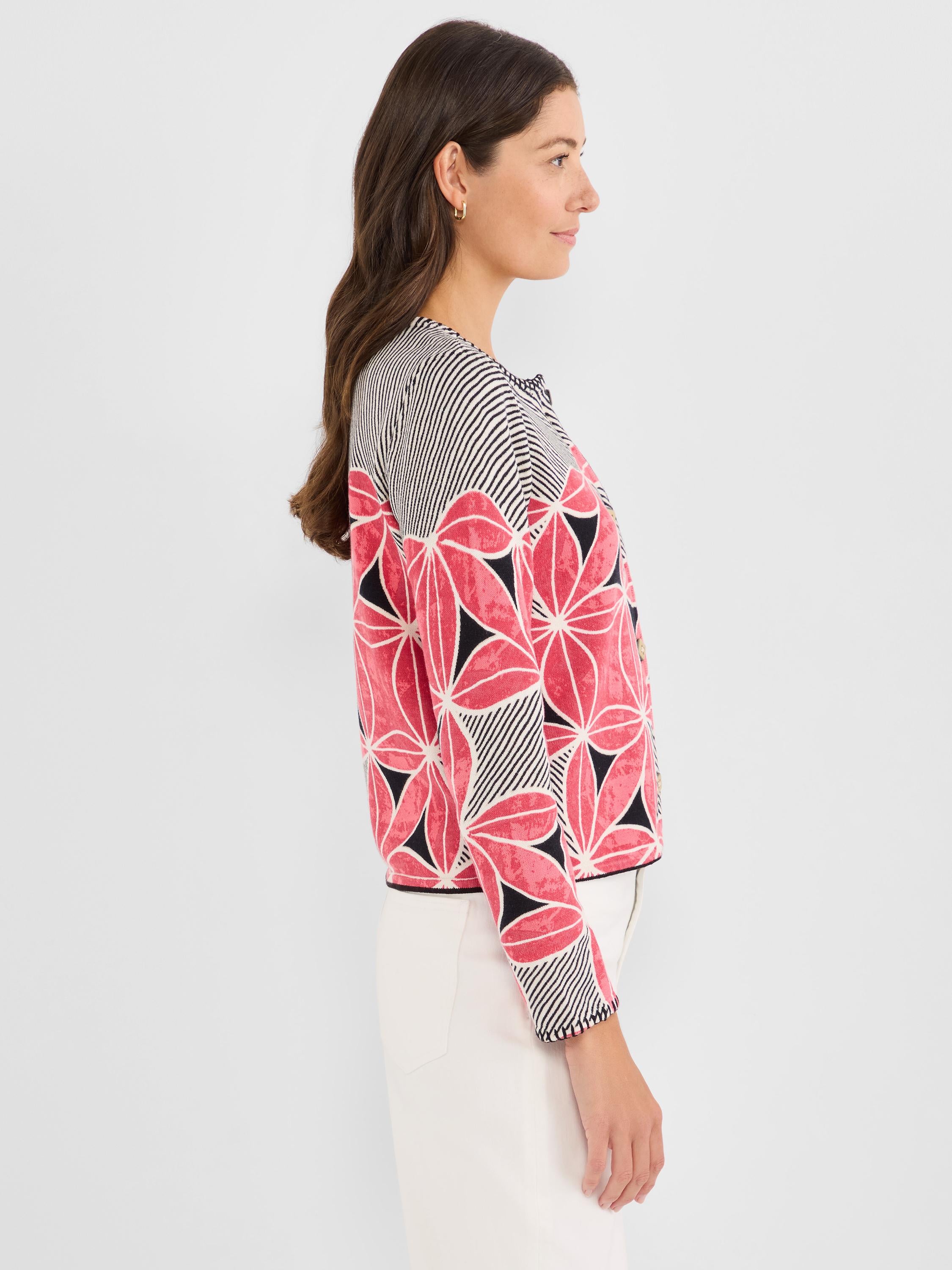 This cropped, collarless knit jacket features bold pink floral designs contrasted by black and white diagonal stripes.