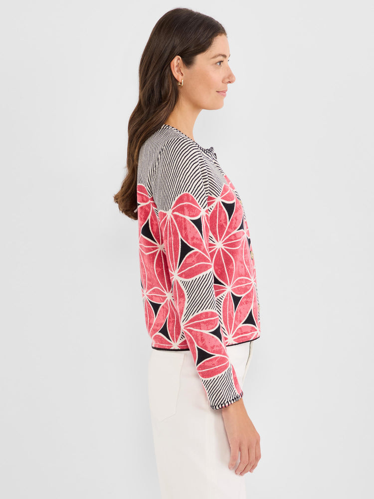 This cropped, collarless knit jacket features bold pink floral designs contrasted by black and white diagonal stripes.