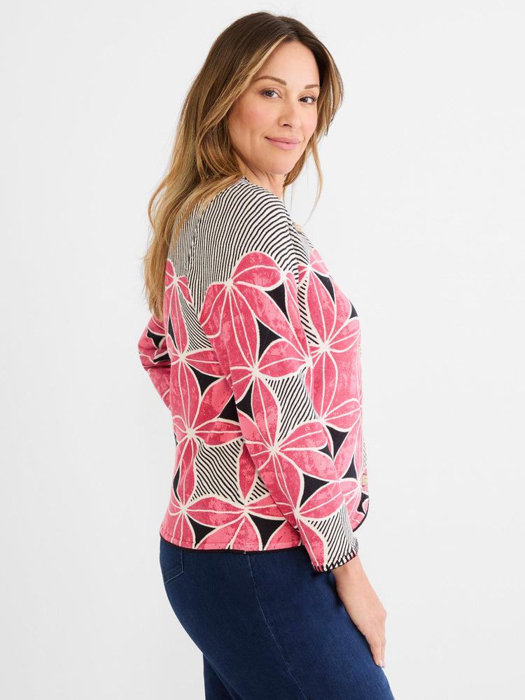 A relaxed fit knit top in pink, black, and white, featuring geometric floral panels mixed with bold stripes.