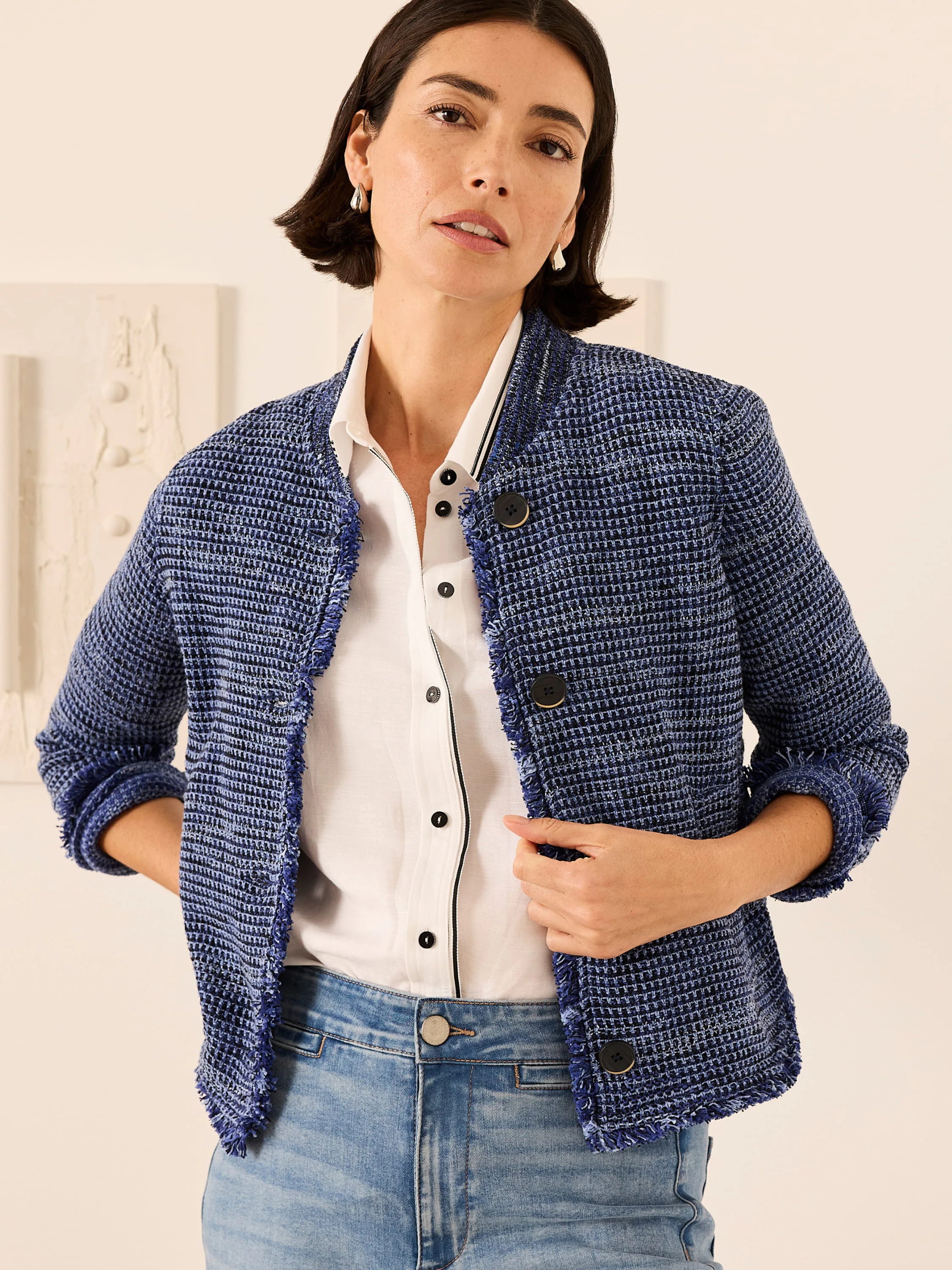Textured blue knit jacket with fringe along open front and rolled cuffs. Features dark buttons.