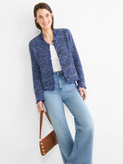 Blue knit bomber jacket with fringe trim on edges and dark buttons.