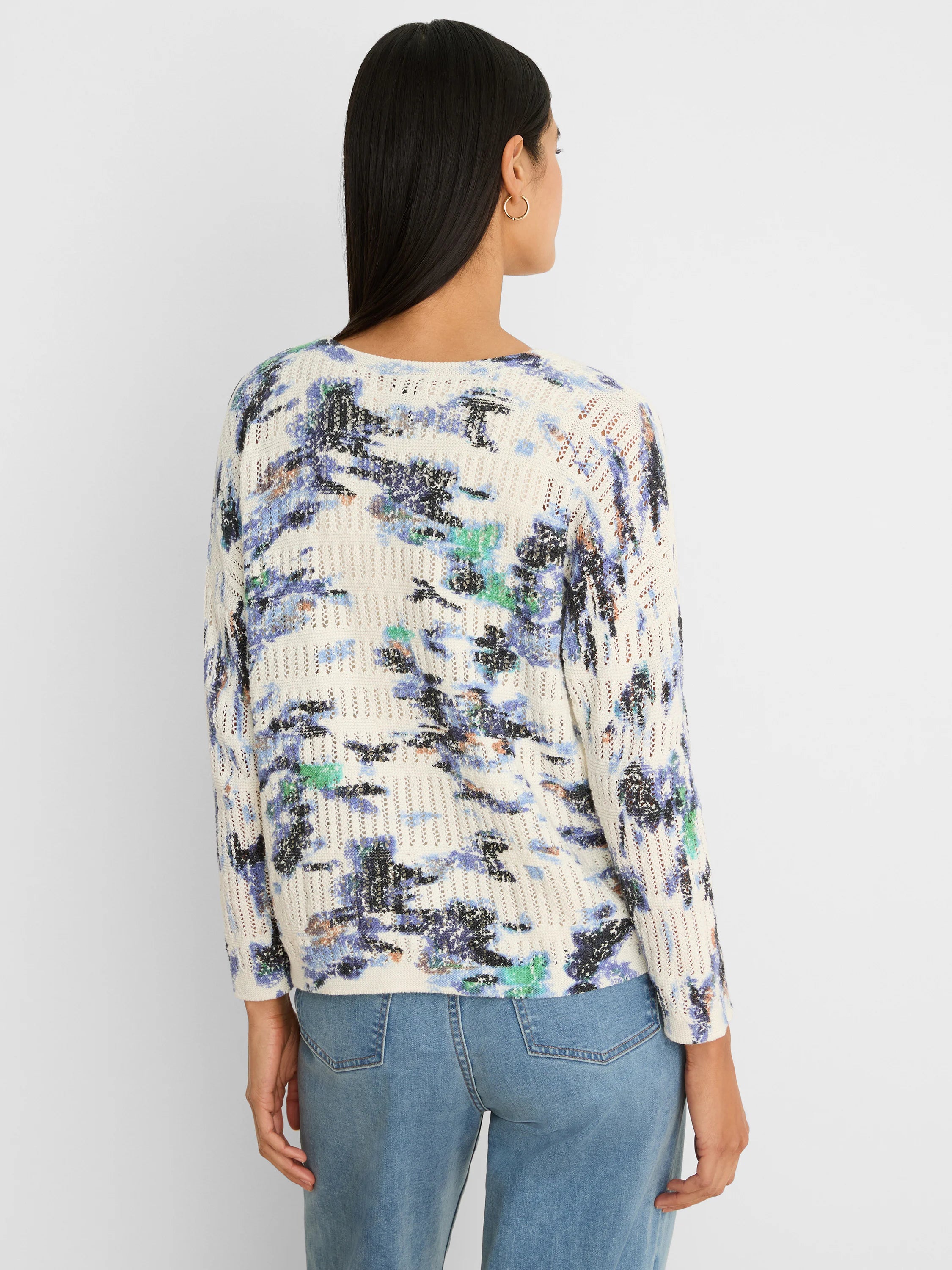 Cream pointelle sweater with abstract blue, green, black, and tan "Water Lilies" pattern, worn from the back.