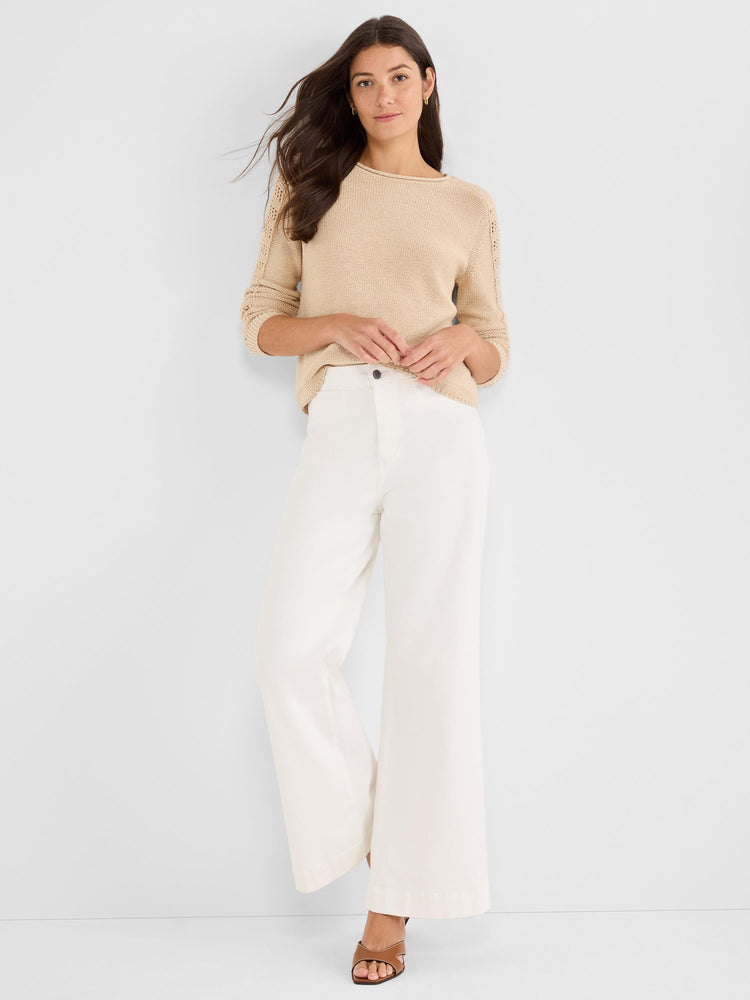 Relaxed tan knit sweater with pointelle three-quarter sleeves and a boat neck, styled tucked into high-waisted white.