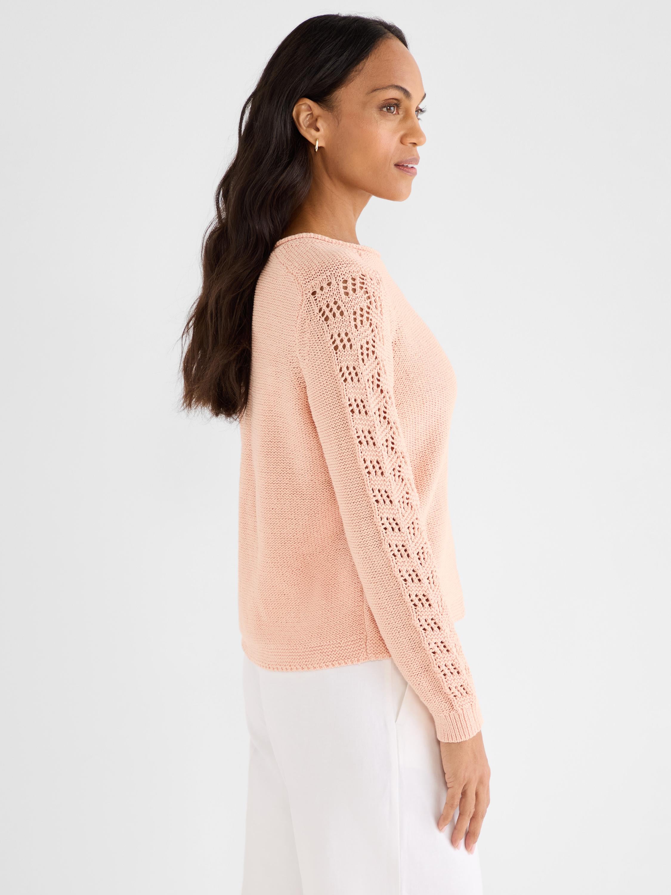 This standard fit peach knit features long sleeves accented by a detailed vertical open lace pattern.