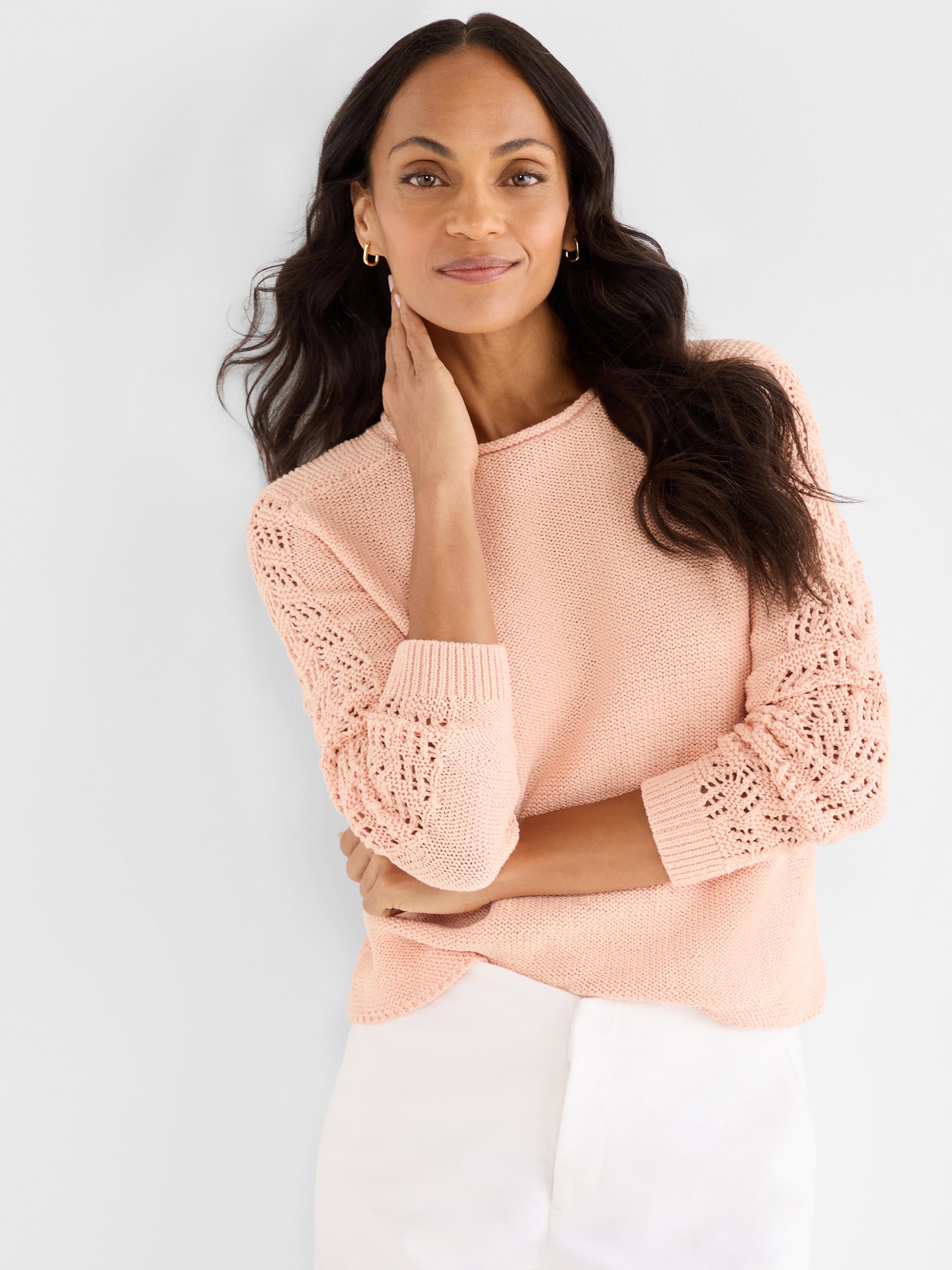 This relaxed peach knit crewneck sweater features subtle eyelet detailing on the long sleeves and standard ribbed cuffs.