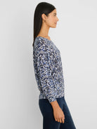 Loose-fit sweater with an abstract indigo, light blue, and white crosshatch pattern. Features a wide neckline.
