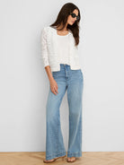 White, slightly cropped open-front jacket with an all-over floral lace pattern and 3/4 length sleeves.
