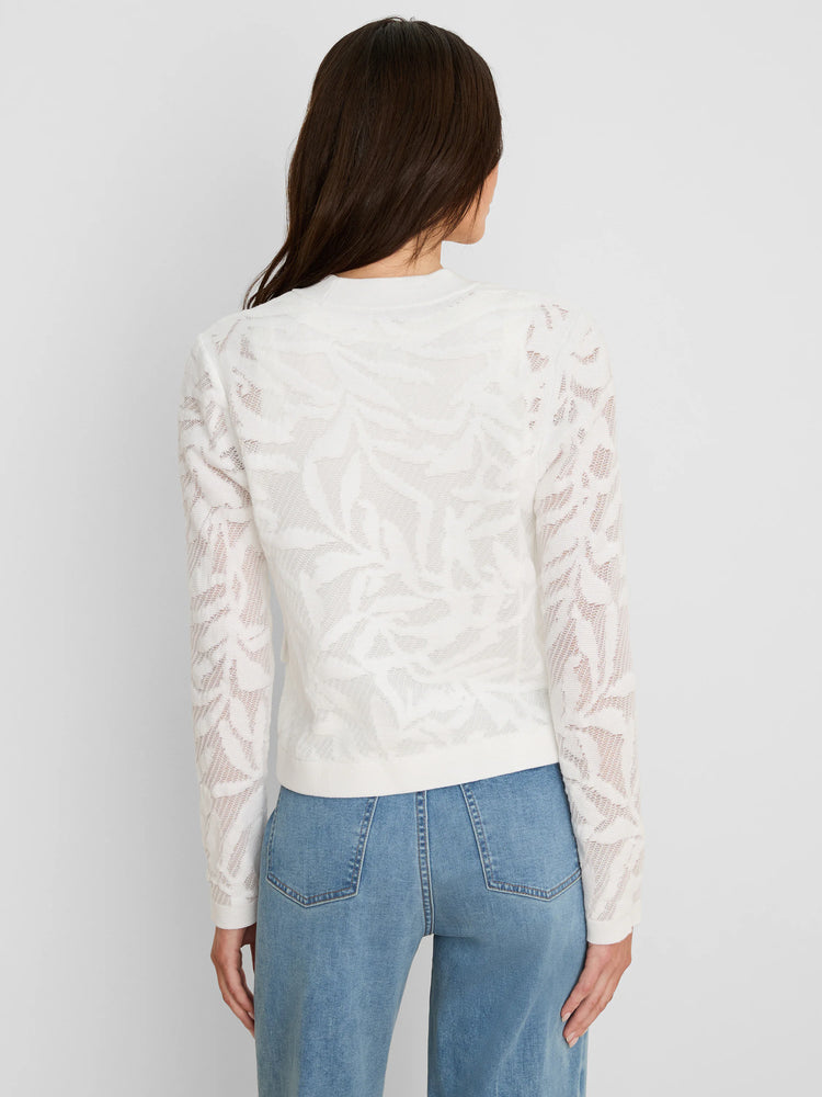 White jacket with an open-knit leaf pattern, shown from the back on a model wearing blue jeans.
