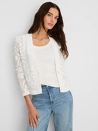 White lace jacket with sheer floral pattern, long sleeves, and front pockets.