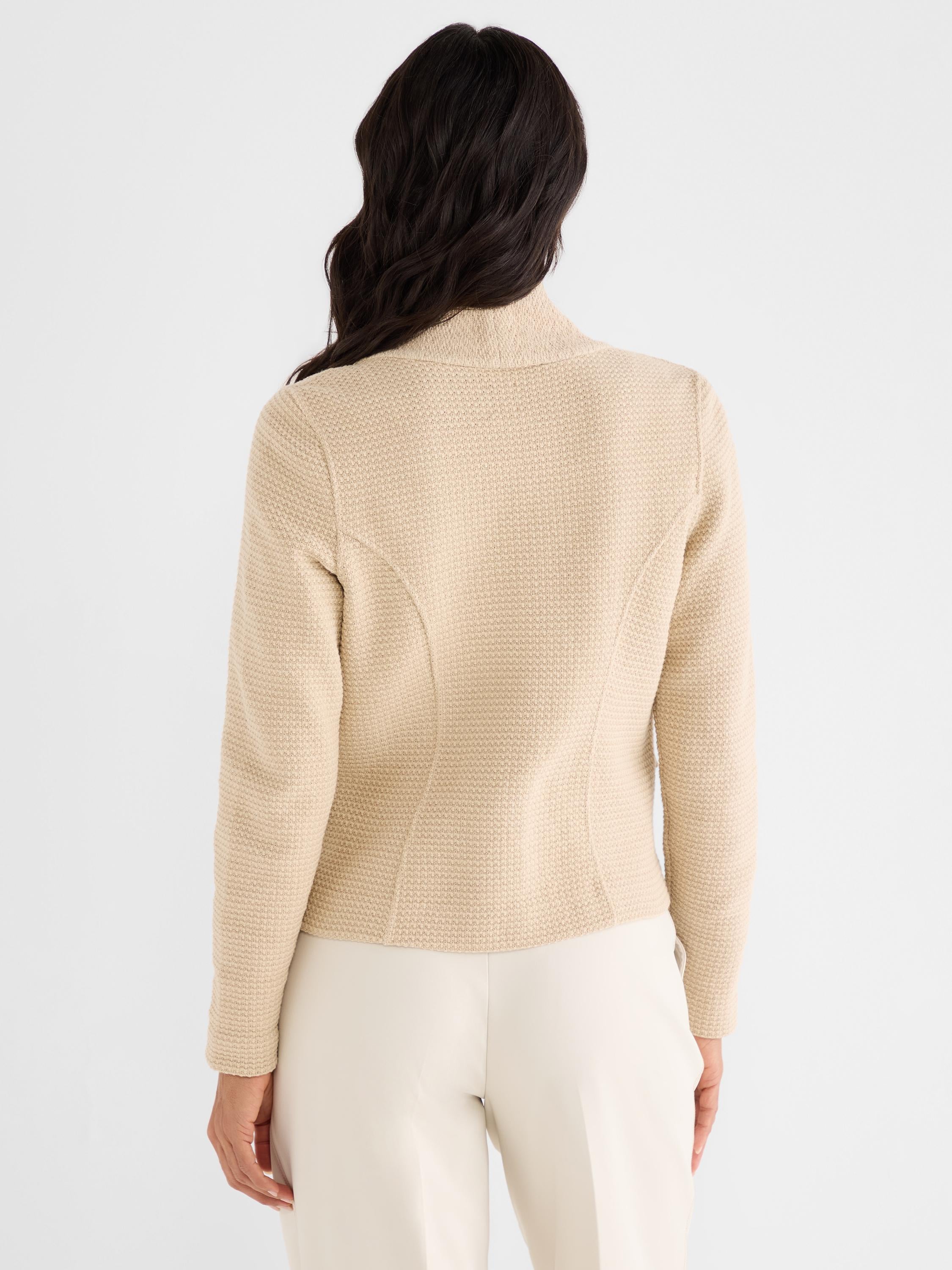 This fitted beige textured knit jacket features a high collar and curved back seams, worn by the model from behind.