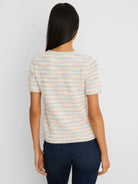 Back view of a cream short-sleeve sweater tee with a multi-color yarn mix, forming faint horizontal stripes in the knit.