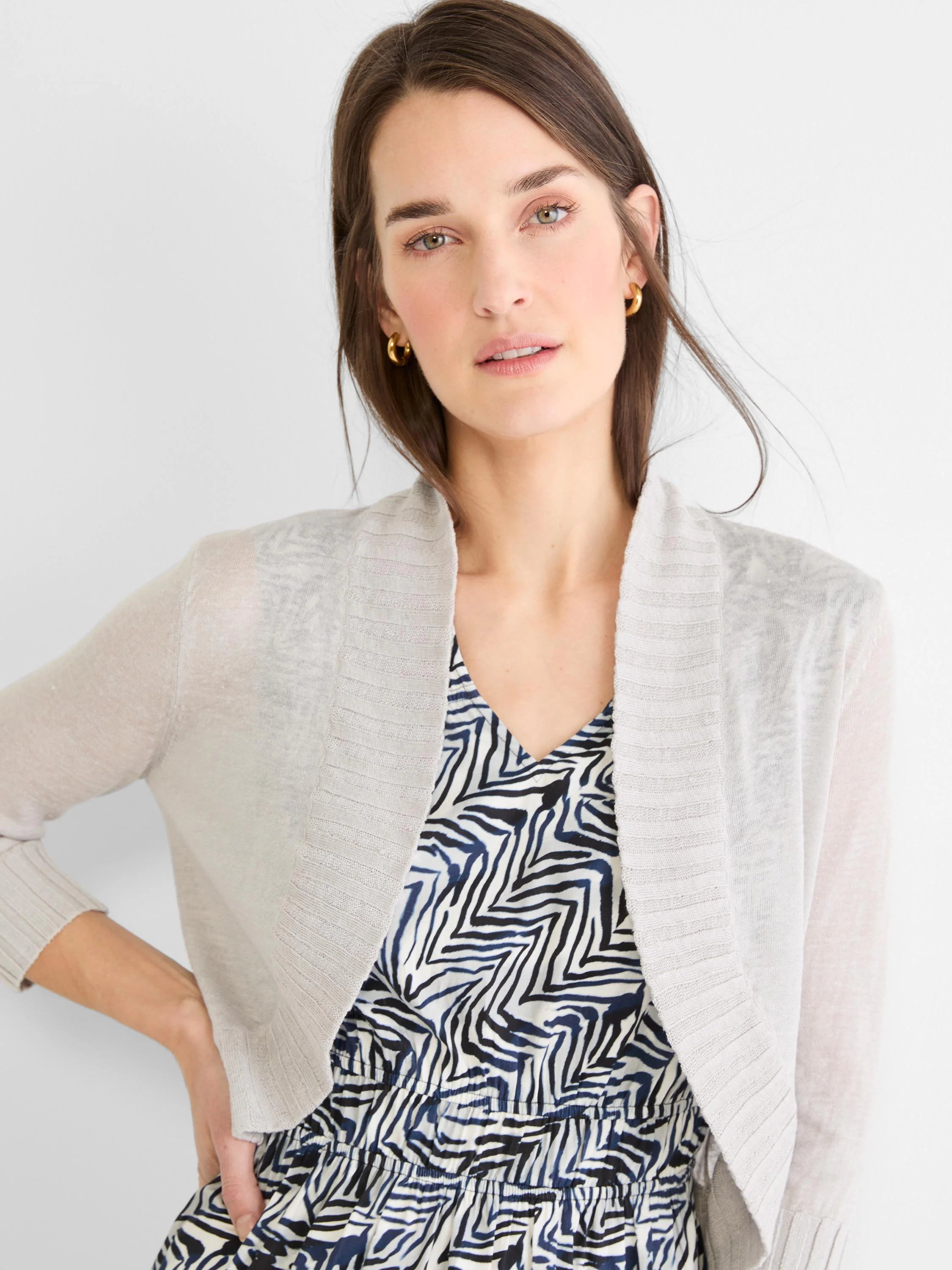 Light grey knit bolero cardigan with open front, long sleeves, and ribbed cuffs and front edges.