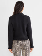 Model wears a fitted black textured knit jacket with a mock neck and subtle frayed hem and cuffs.