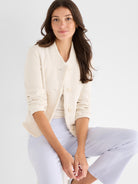 A model wears a tailored cream tweed-style jacket with a collarless design, three buttons, and raw fringed detailing.