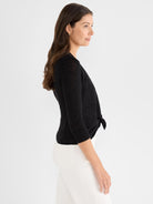 A fitted black lightweight cardigan features three-quarter sleeves and a knot closure tied at the front waist.