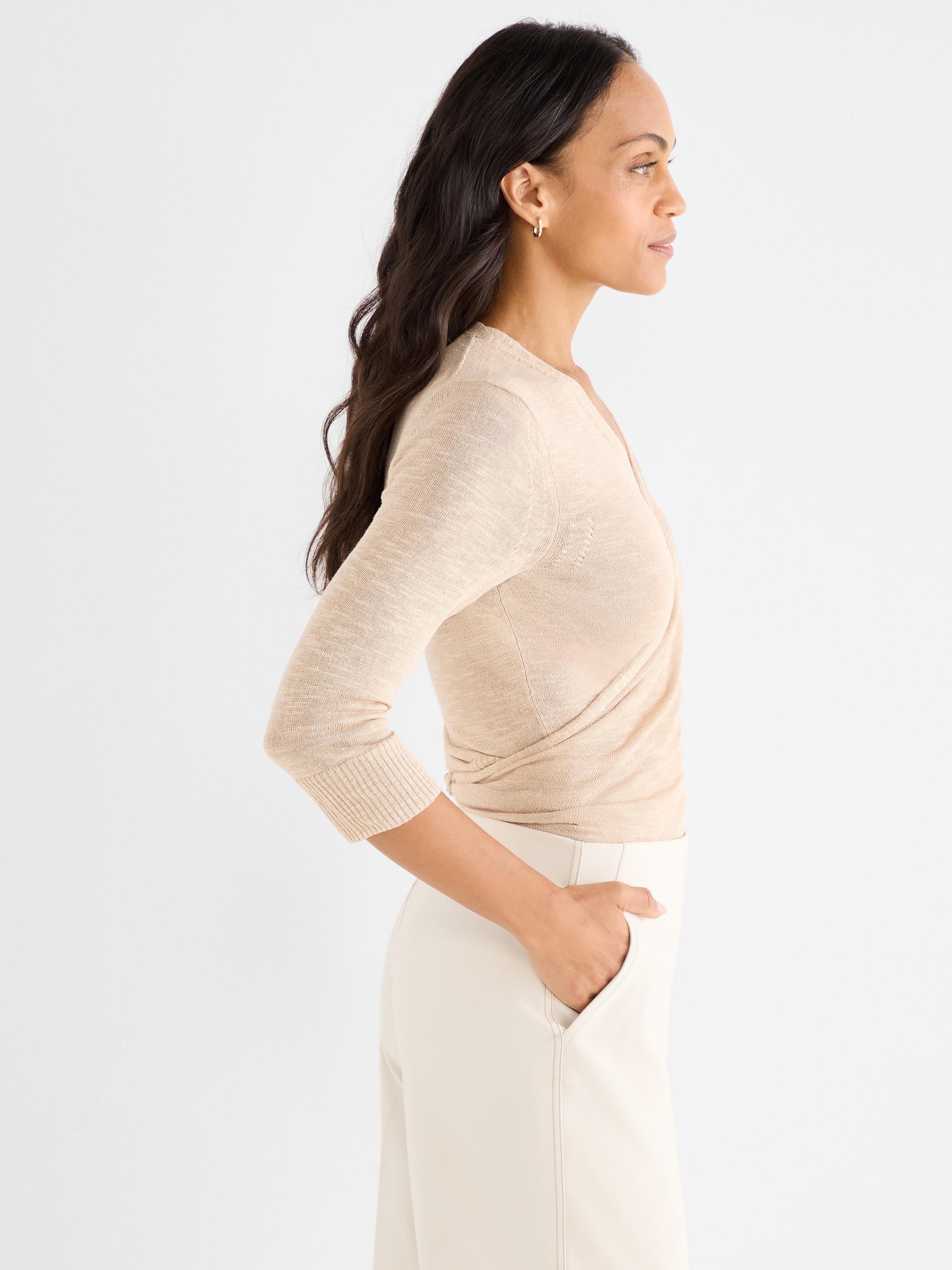 Fitted beige knit wrap top with a deep V-neck and three-quarter length sleeves.