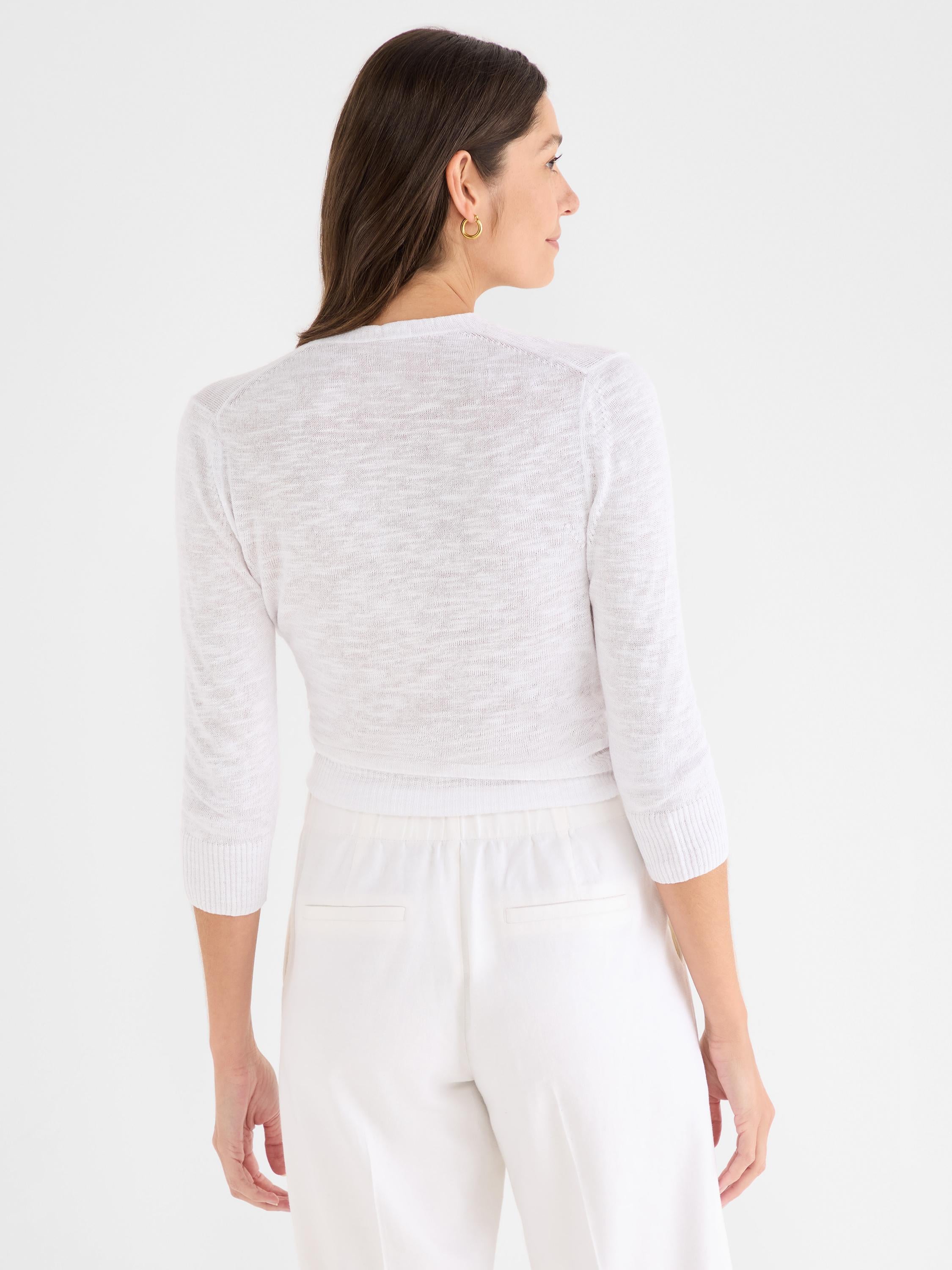 This fitted, cropped white cardigan features lightweight heathered knit fabric and three-quarter sleeves.