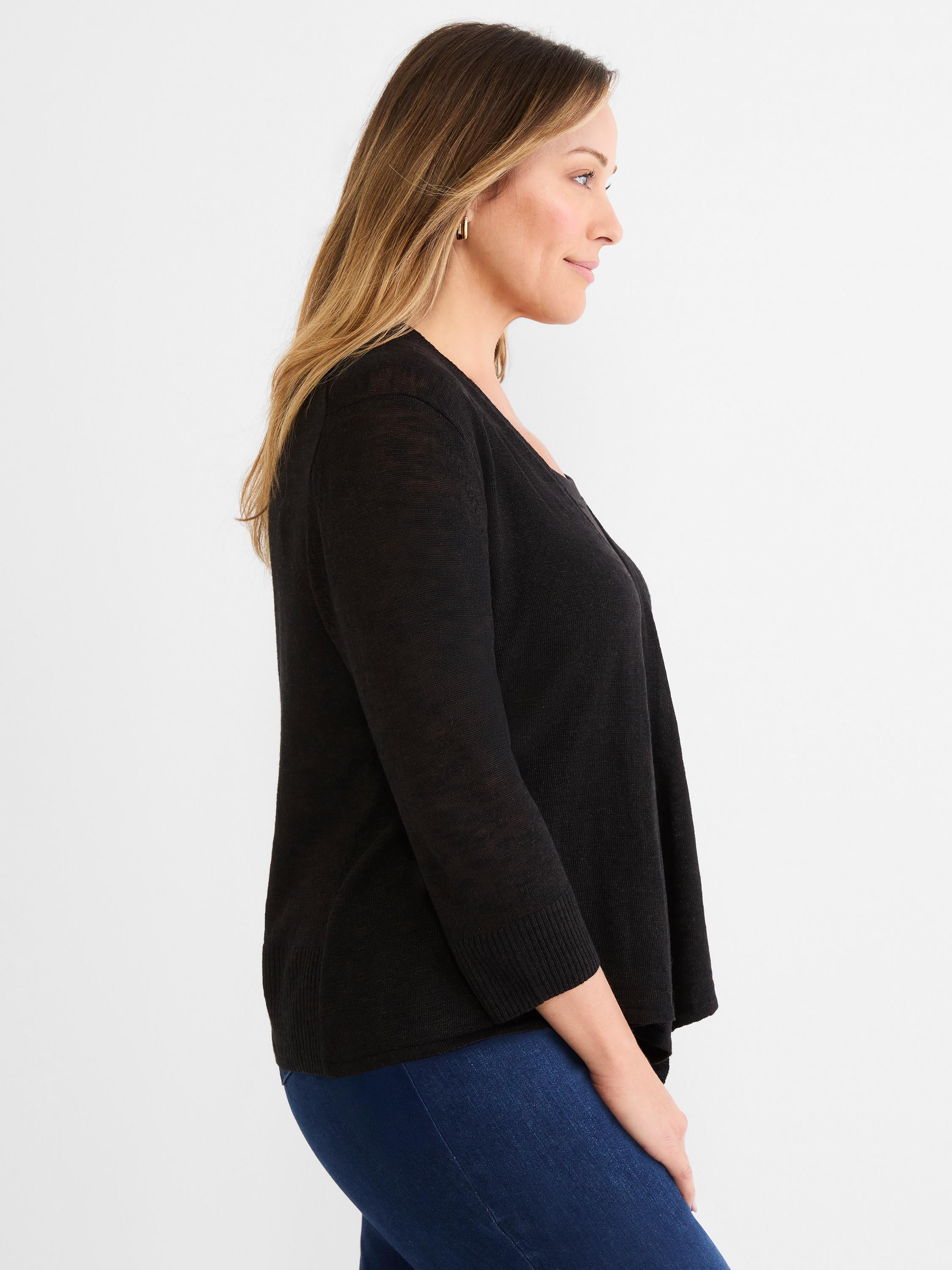 Black lightweight draped open cardigan with three-quarter sleeves, worn by a model over blue jeans.