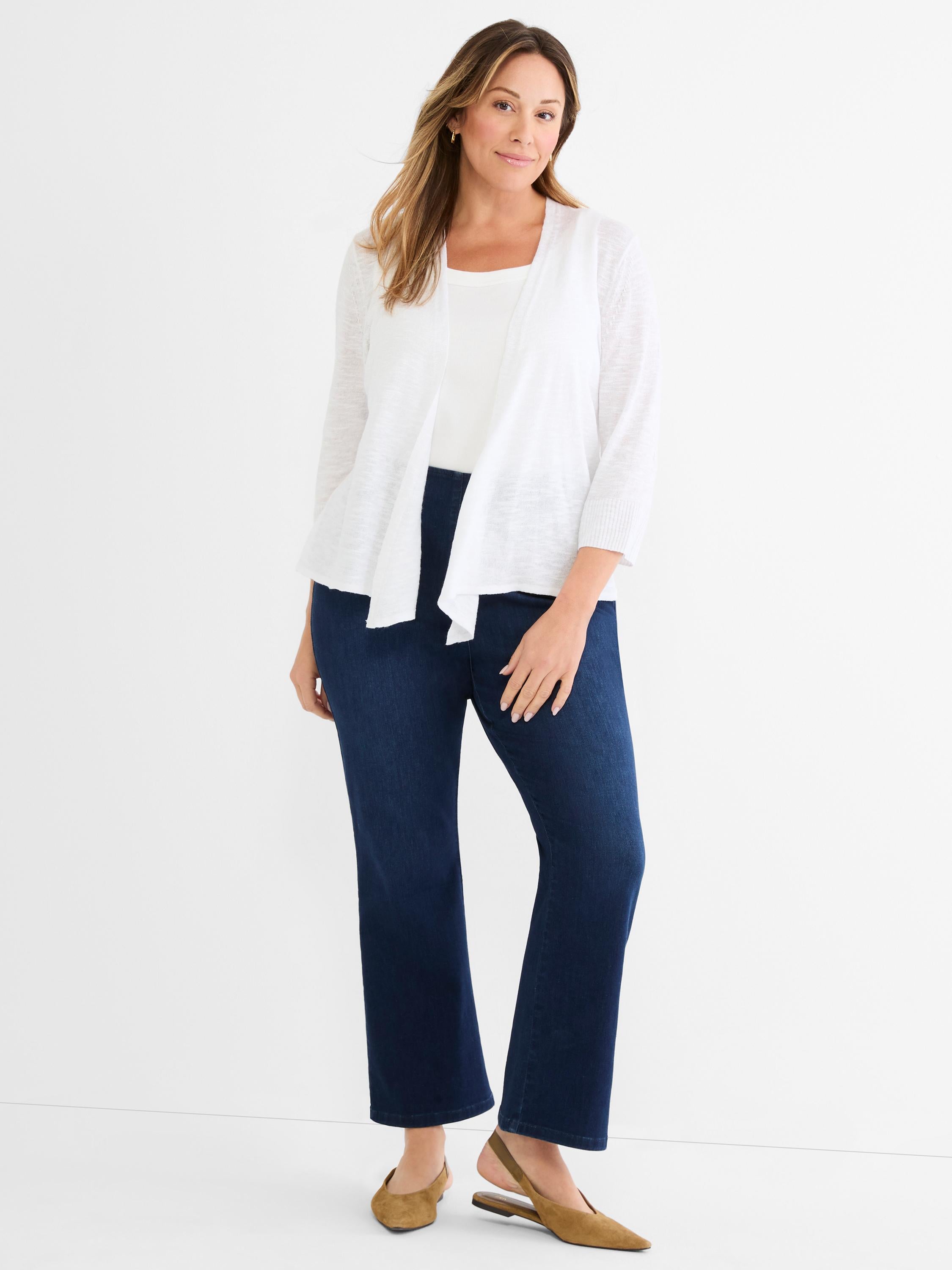 Model wears a lightweight white open-front cardigan with three-quarter sleeves and dark indigo straight-leg jeans.