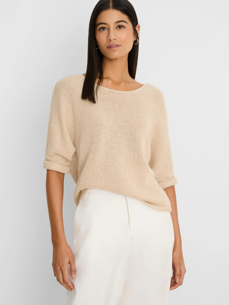 Light beige crimpy cord knit sweater with a boat neck and rolled short sleeves, worn by a model.
